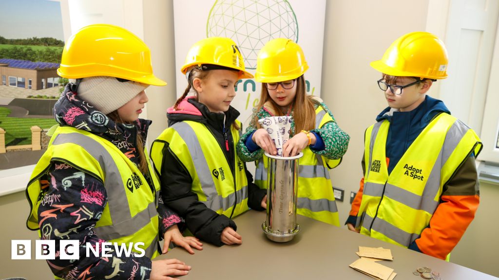 Children bury time capsule at site of urban farm